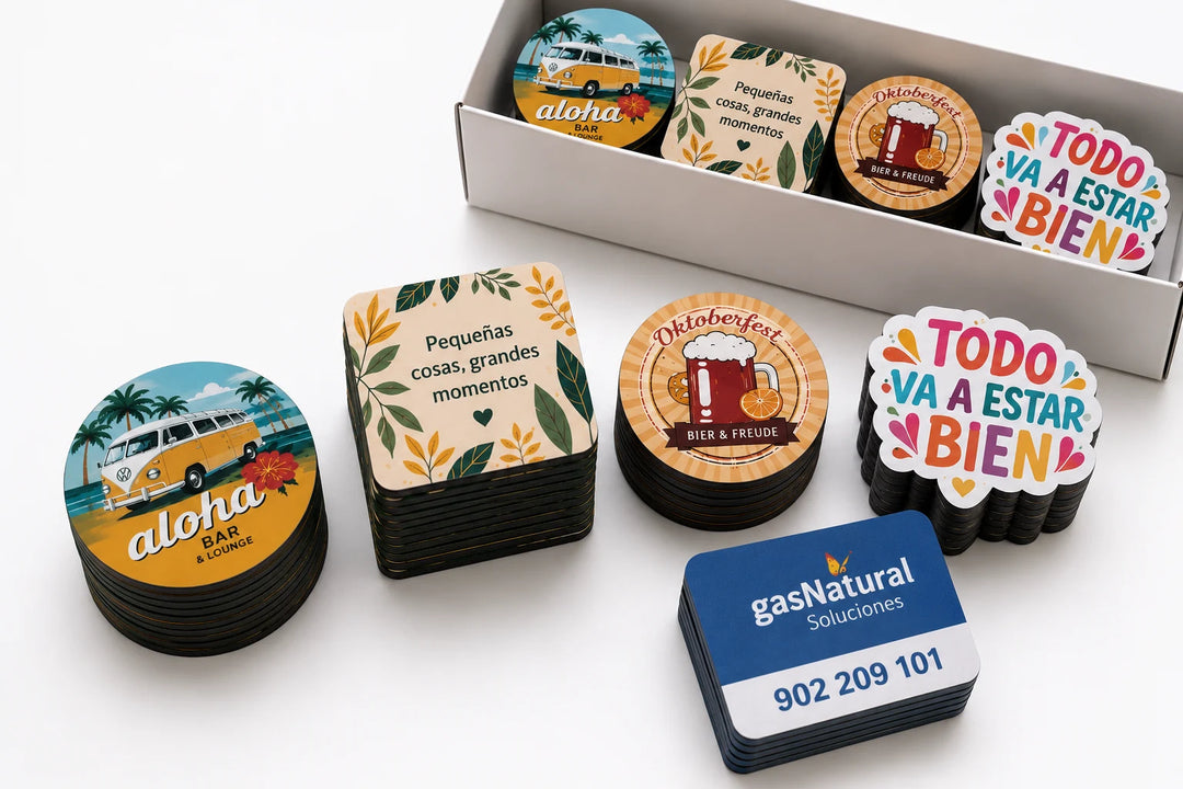 Imanes personalizados impresos en diferentes formas, apilados y empacados en caja.
